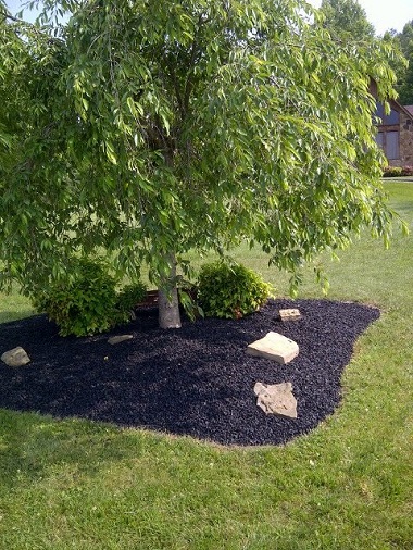 black tire mulch used in a flower bed on the side of a house